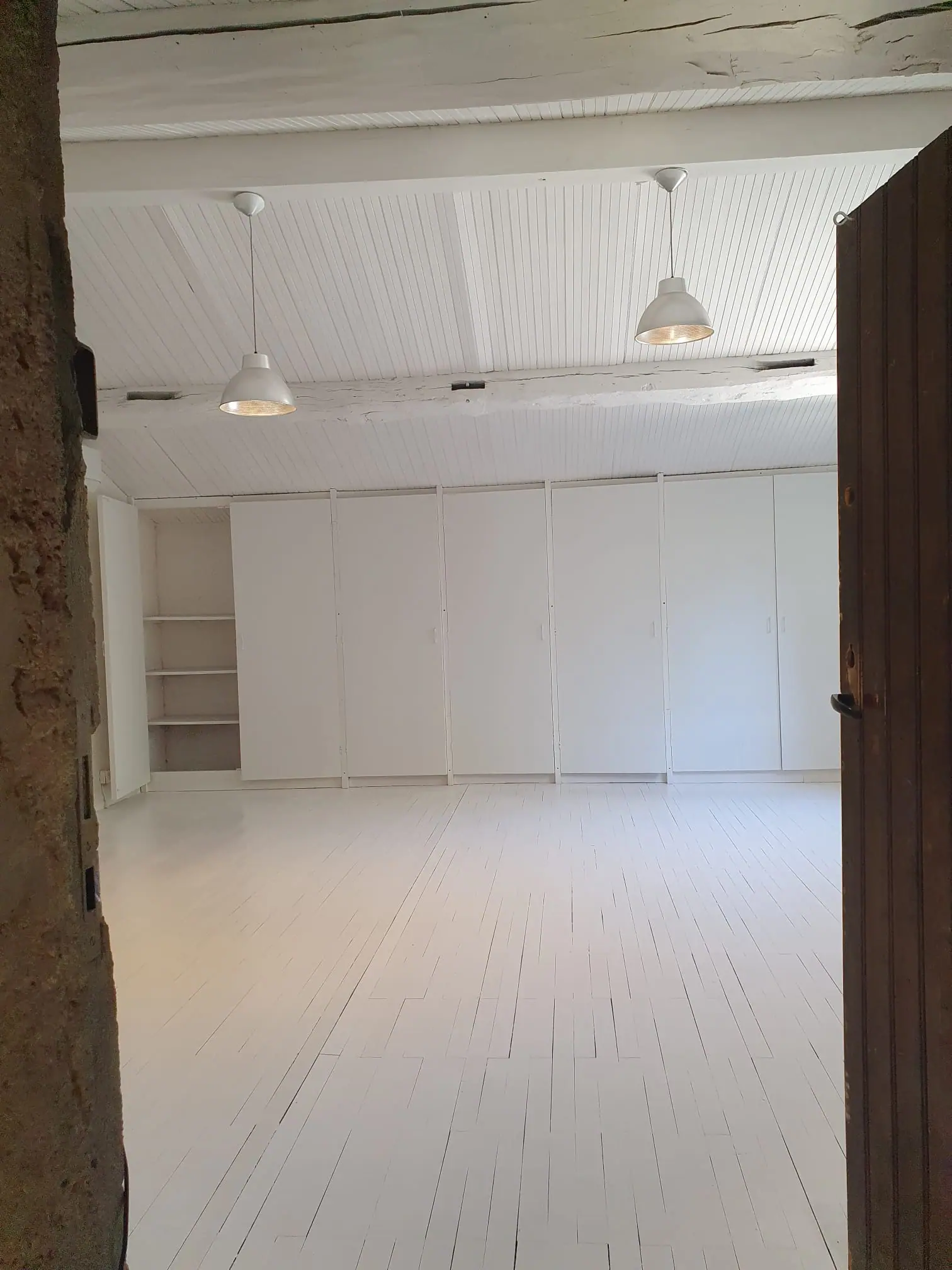 Chantier de Yohan Peinture : pièce aux lambris de plafond, poutres, placards et plancher peints en blanc